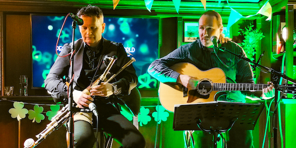 Gareth and Brendan - Irish Ayes - on stage playing guitar and uilleann pipes.
